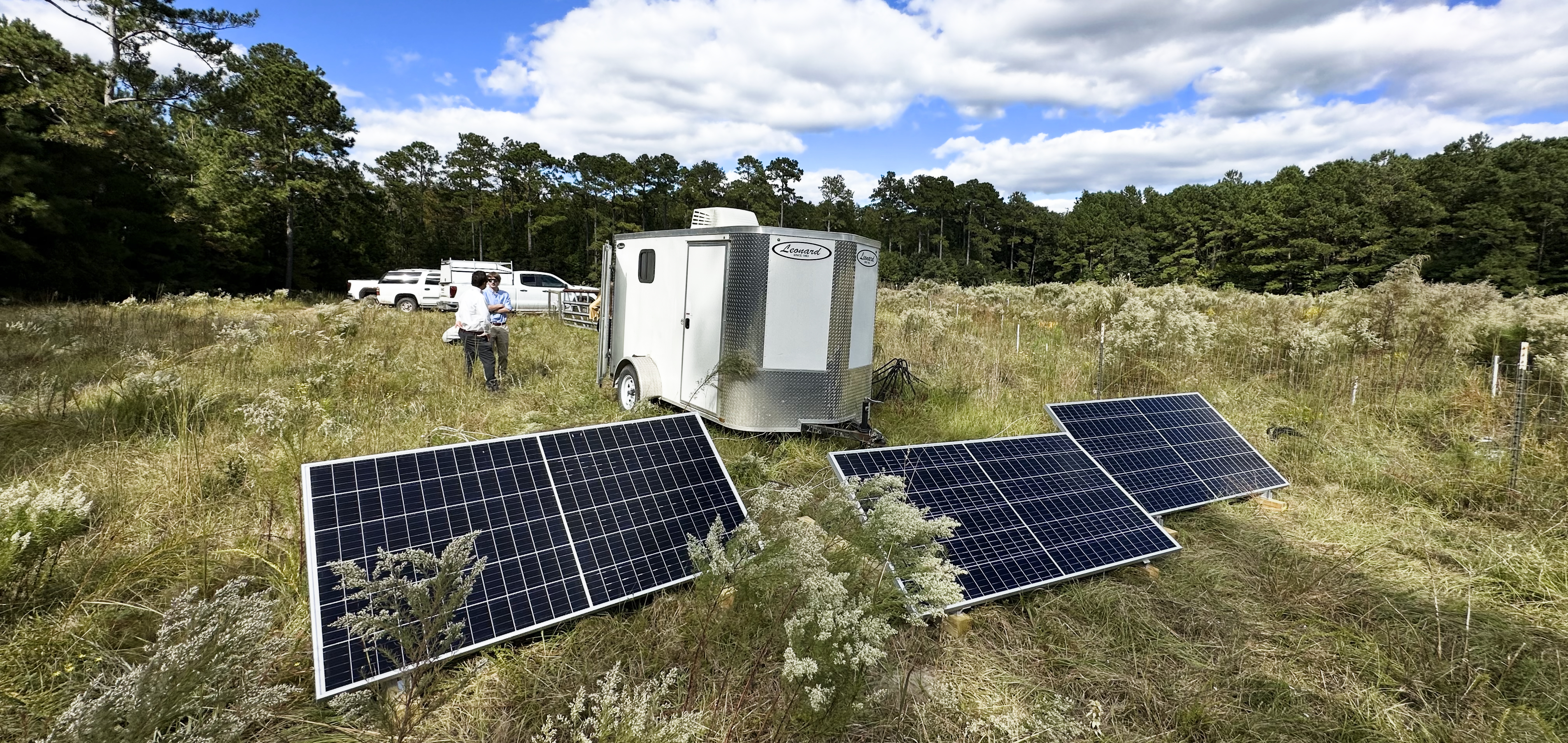 image of a field with a trailer and solar panels